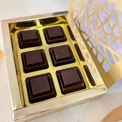 A close-up of the handmade, caramel-filled chocolates included in the Rakhi hamper, presented in a beautiful golden box.