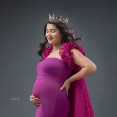 A close-up shot focusing on your serene expression and the details of the gown. The wind effect adds a touch of glamour to this studio maternity portrait.