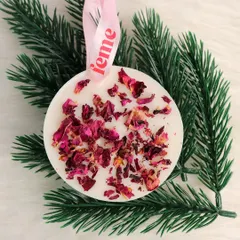 A wardrobe essential. Our rose petal wax sachet hanging on a pine branch, showing its versatility for festive decor.