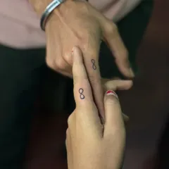 Matching infinity symbol tattoos on the fingers for a couple. This is a popular and subtle way to symbolize an everlasting bond.