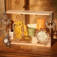 This yellow-themed Diwali hamper is pure sunshine. It comes in a reusable wooden crate and is filled with a silk potli, snacks, and beautiful silver-finished 'Shubh' and 'Labh' hangings.