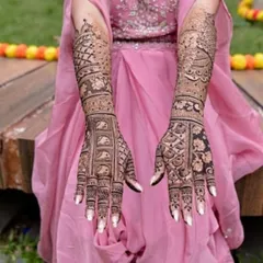 A beautiful example of a full bridal mehandi with a focus on symmetry and clean patterns. The white nails make the dark henna stain pop.