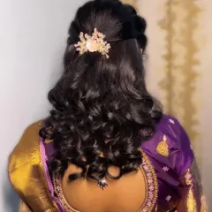 A half-up, half-down hairstyle with soft curls. This is a versatile and popular choice for receptions and parties, adorned with a delicate hair clip.