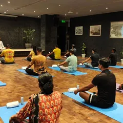 A wide view of a corporate yoga class, showing a spacious and calming setup. I ensure every session, whether on-site or virtual, provides a genuine escape for employees to rejuvenate their minds and bodies.