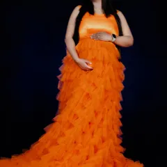 Our orange ruffle gown is vibrant and full of life. The cascading ruffles create a beautiful texture and a long, flowing train for dramatic photos.