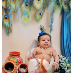 Your little one transformed into a divine little Krishna. This setup features traditional pots and a peacock feather backdrop, perfect for a memorable Janmashtami baby photoshoot.