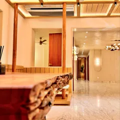 This shot from the live-edge dining table looks out into the main corridor, showing how the spaces connect. The polished marble floor reflects the light beautifully, contrasting with the warm wood of the dining area and creating a seamless flow.