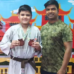 This young champion showcasing his two medals from the Open National Karate Championships. His hard work has truly paid off.