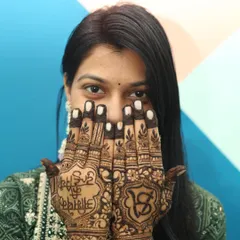 This shot highlights the detailed bridal mehandi design, with the bride's initials cleverly worked into the pattern. It’s a creative portrait that documents the traditional artistry of the ceremony.