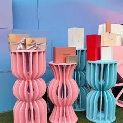 A close-up of the custom-fabricated display stands for the Ajio Luxe event. The unique, curved design in pink and blue adds a modern, artistic touch while elegantly showcasing the luxury products.