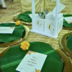 We honour heritage with our presentation choices. This table setting features a traditional banana leaf on a brass thali, complemented by our custom-branded cutlery holder, blending tradition with elegance.