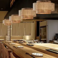 Our drum-shaped rattan pendant lights are a popular choice for restaurants and cafes seeking a modern yet natural aesthetic. Hung in a series over a long table, they provide focused light while adding a strong decorative element to the interior design.