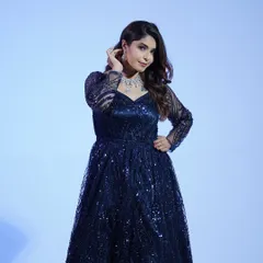 A close-up of the navy blue gown, showing off the intricate sequin pattern on the sleeves and bodice. It’s all about the sparkle.