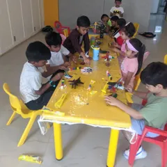 A table full of young innovators working on various projects, from painting models to assembling kits. There is always something new to create.