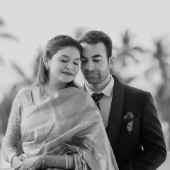 A timeless black and white portrait that exudes elegance. The focus is on their serene expressions and the beautiful texture of the saree, creating a classic and artistic image.