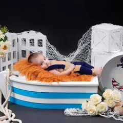 Ahoy, little sailor. This nautical-themed studio setup with a boat prop and anchor detail is perfect for your little adventurer.