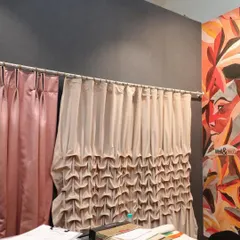 A showcase of our diverse curtain craftsmanship. On the left, a simple yet elegant pink satin drape, and on the right, a custom-designed curtain with intricate, hand-gathered ruching, demonstrating our ability to create unique and complex drapery styles.