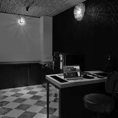 In this workspace, we used dramatic wall-mounted lights that cast starburst patterns, transforming a simple wall into a feature. The interplay of light and shadow is contrasted with the classic checkerboard floor and a rustic bamboo ceiling.