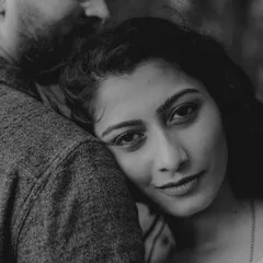 A stunning black and white close-up. Her serene expression as she rests her head on his shoulder creates a powerful, emotional, and beautifully artistic portrait.
