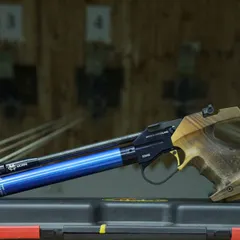 A detailed shot of an Anschutz air pistol with a custom wooden grip, showcasing the precision and quality of the firearms used in our sessions.