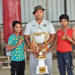 Posing with two of my promising young male boxers after a successful competition. They are holding their medals and the winner's trophy, a testament to their commitment to the sport.