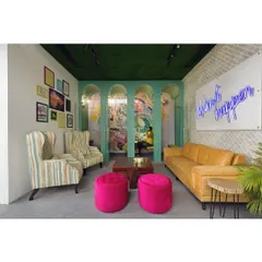 Another view of the vibrant lounge, showcasing the interplay of textures like the faux grass ceiling and exposed brick, with bold furniture choices. This eclectic mix creates a comfortable yet stimulating space for informal meetings and collaboration.