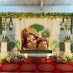 A slightly different angle of the Krishna-themed decor, showing the ornate chairs placed for the ceremony. The details in the artwork and floral arrangements come together perfectly.