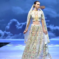 Another angle of the floral embroidered ivory lehenga. The sheer dupatta is edged with matching work, framing the bride with ethereal grace.