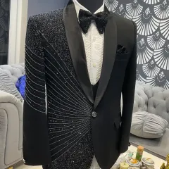 This black tuxedo features an asymmetrical design with one side heavily embellished with radiating lines of black crystals. It's a modern, artistic take on the classic groom's tuxedo.