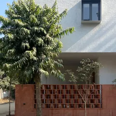 The facade of the Jaipur House, where the clean lines of the modern structure contrast with the intricate, earthy red sandstone jali. This view highlights our approach to blending old and new in a single, cohesive architectural narrative.