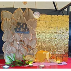 A '50 & Fabulous' backdrop combining a gold sequin wall with dried palm leaves. This design is modern, stylish, and perfect for a milestone celebration.