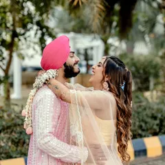 A beautiful, happy moment from an Anand Karaj celebration. Her joyful laugh as she embraces him is infectious. Capturing these genuine emotions is what makes a photograph truly memorable.
