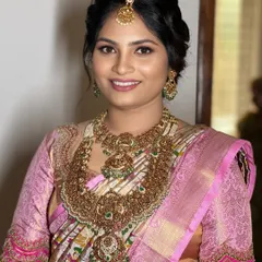Elegance personified, this bride embodies a perfect blend of traditional and contemporary style. Her pink printed saree and antique jewellery are complemented by a soft, romantic hairstyle.
