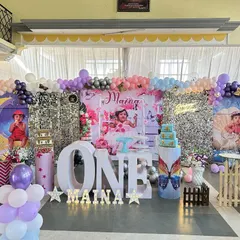 A grand butterfly theme in a hall, featuring a silver shimmer wall and personalized backdrops with the birthday girl's photos. The large 'ONE' marquee letters and pastel balloon arch complete this elaborate first birthday stage.