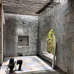 A work-in-progress shot showing our mason meticulously laying random-patterned stone cladding. This level of craftsmanship and attention to detail is what gives our projects their unique, tactile quality.
