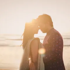 As the sun melts into the sea, their silhouettes tell a story of quiet love. We chase this golden hour light to create timeless, romantic portraits.