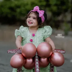 Capturing the pure, unfiltered joy of childhood is what we love most. This outdoor portrait for Bhoomija's first birthday shoot shows her delightful personality shining through as she plays with her little walker.