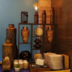 An elaborate decor shelf used as part of a festive buffet. The antique finish lanterns and vases create a rich, traditional ambiance perfect for Indian festivals and weddings.