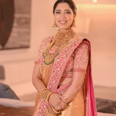 A radiant bride in a beautiful Kanjivaram saree. Her hair is styled in a traditional South Indian updo, perfect for her family wedding.