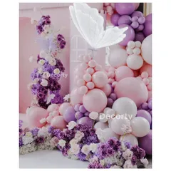 A close-up of the decor, showing a large, glowing white butterfly perched on a cloud of pink and purple balloons and flowers.