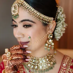 A stunning close-up of a bride in her traditional red lehenga, showcasing her intricate jewelry and flawless makeup.
