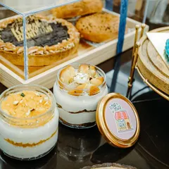 My Rakhi hampers often pair larger bakes with smaller, individual treats. Here, you can see my popular dessert tubs, like the tres leches and motichoor, alongside a larger gift box.