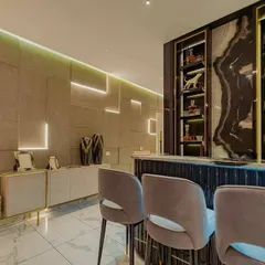 This home bar area in the Sushma sample flat uses multiple layers of light. I integrated linear LED strips into the wall panels and shelving to create a geometric pattern and highlight the decor, making the bar a glowing feature within the living space.