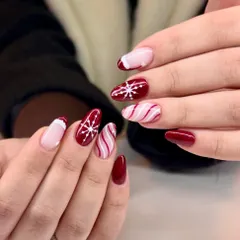 Snowflakes, candy stripes, and zero subtlety. This winter nail set is done right, with a deep red base, crisp white details, and a fun mix of patterns.