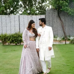 A couple takes a romantic walk through a garden, dressed in exquisite traditional Indian clothing. This image combines the beauty of nature with the elegance of their attire.