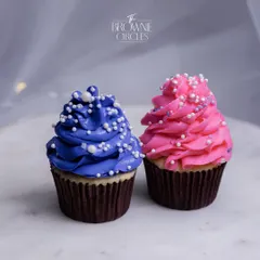A pair of beautifully decorated cupcakes, one with pink frosting and the other with purple. Perfect for parties, gifts, or a simple moment of indulgence.