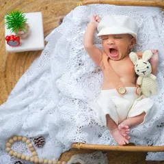Another adorable yawn, this time with a little cap and a stuffed bunny. These small additions to the setup add a touch of whimsy to the portrait.