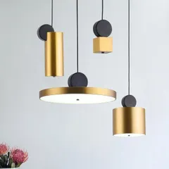 This collection of geometric pendants can be mixed and matched to create a custom lighting arrangement. Featuring cylinders, discs, and cubes in a brushed gold and black finish, they are perfect for a modern, eclectic interior.