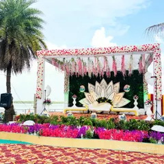 Our team can bring any theme to life, like this stunning lotus-themed mandap set against a serene waterfront. The combination of the natural backdrop, lush greenery, and unique floral structure creates a picturesque setting for an engagement or wedding.