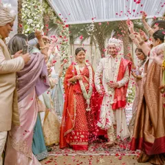 Payal and Udyat walk down the mandap as husband and wife, showered with rose petals by their loved ones. This is the beautiful culmination of their morning wedding ceremony, a moment of pure happiness.